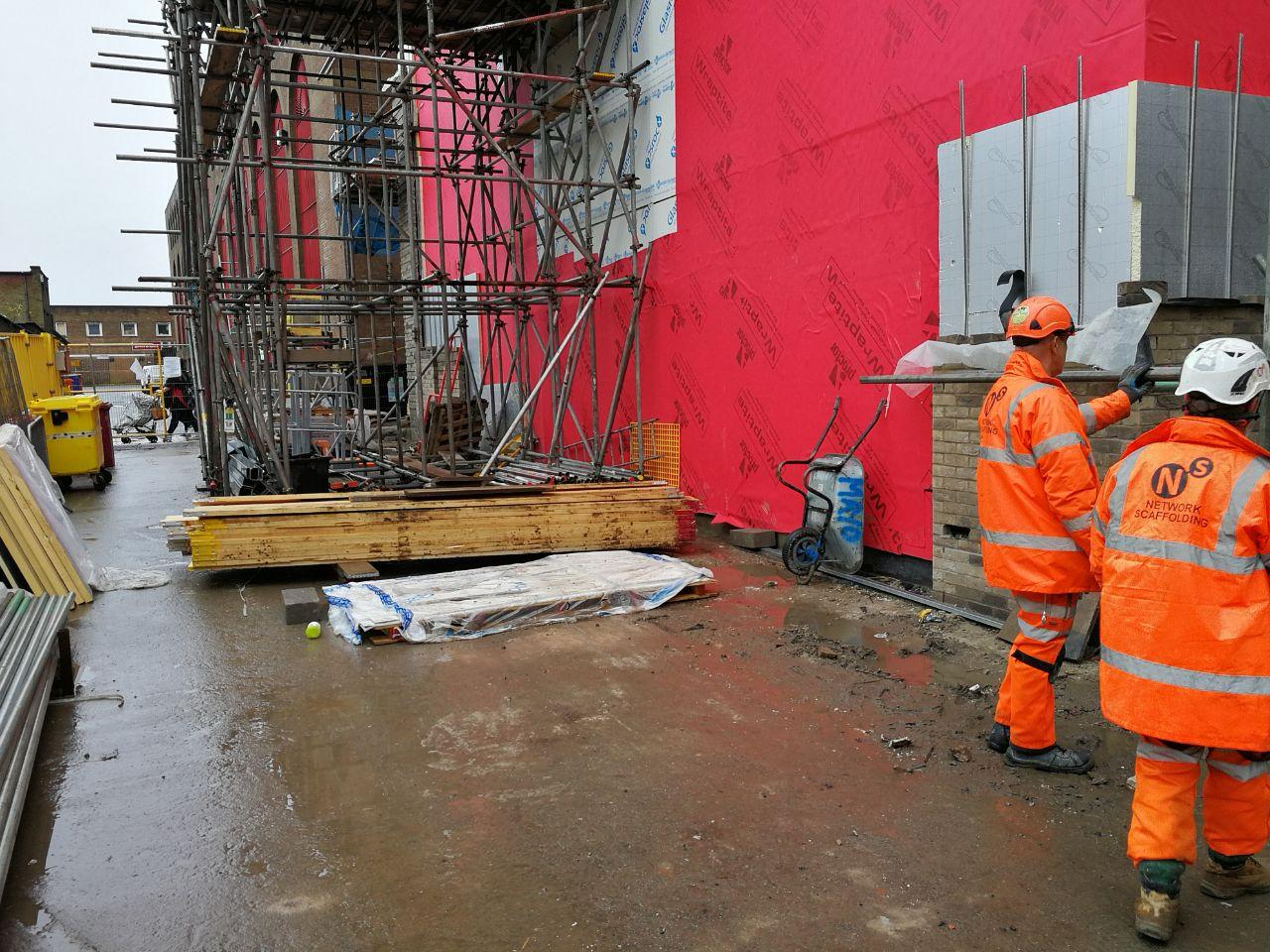 Construction team working beside the theatre's red external wall