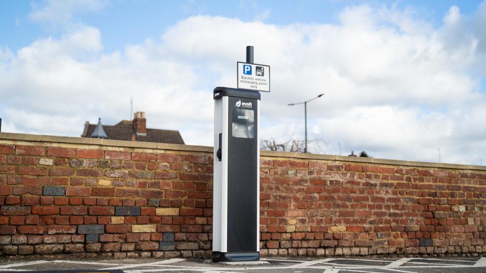 EV charging pedestal installed in front of a retained brick wall