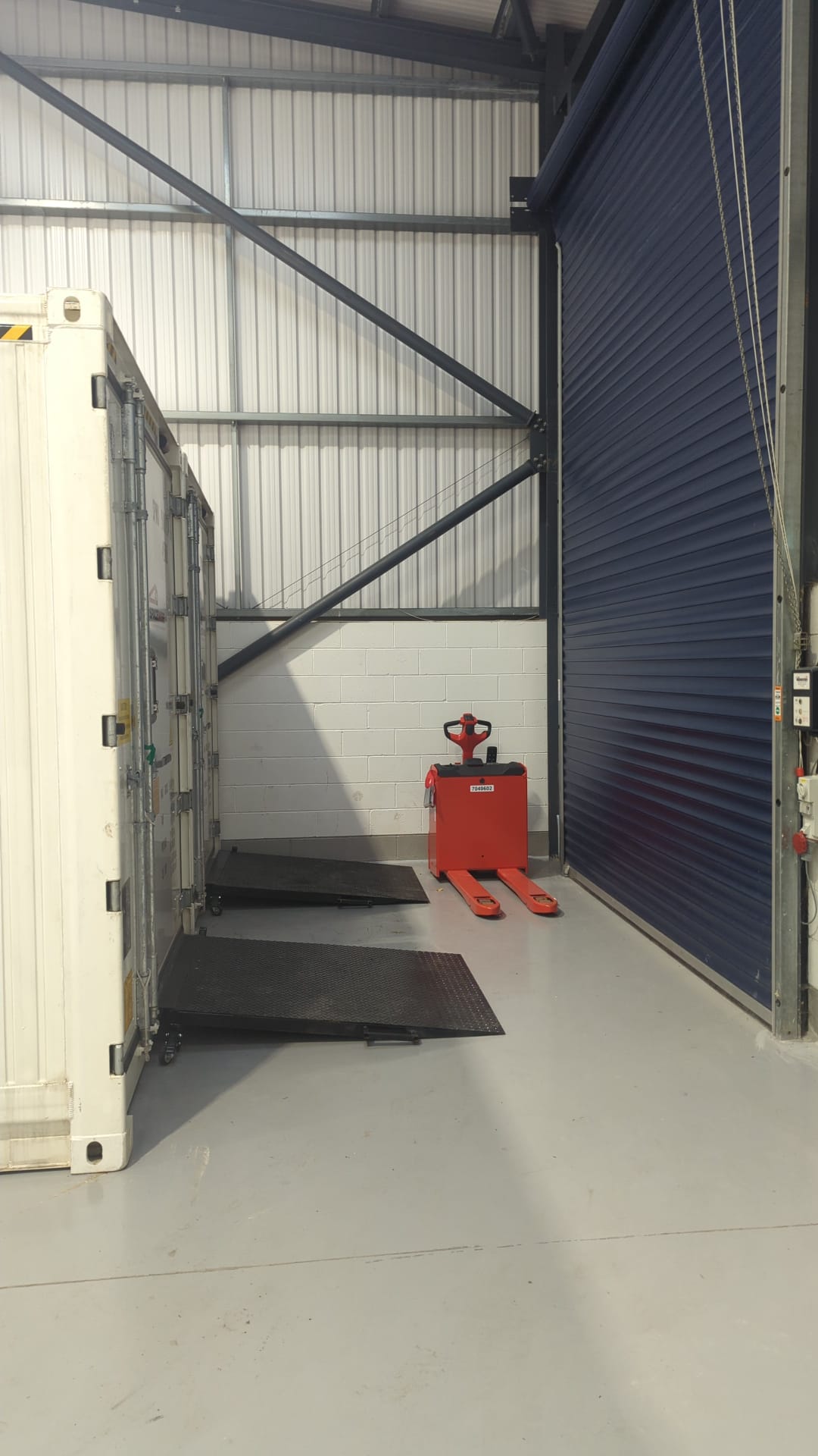 Self-contained refrigeration unit positioned internally with access ramp and roller shutter door