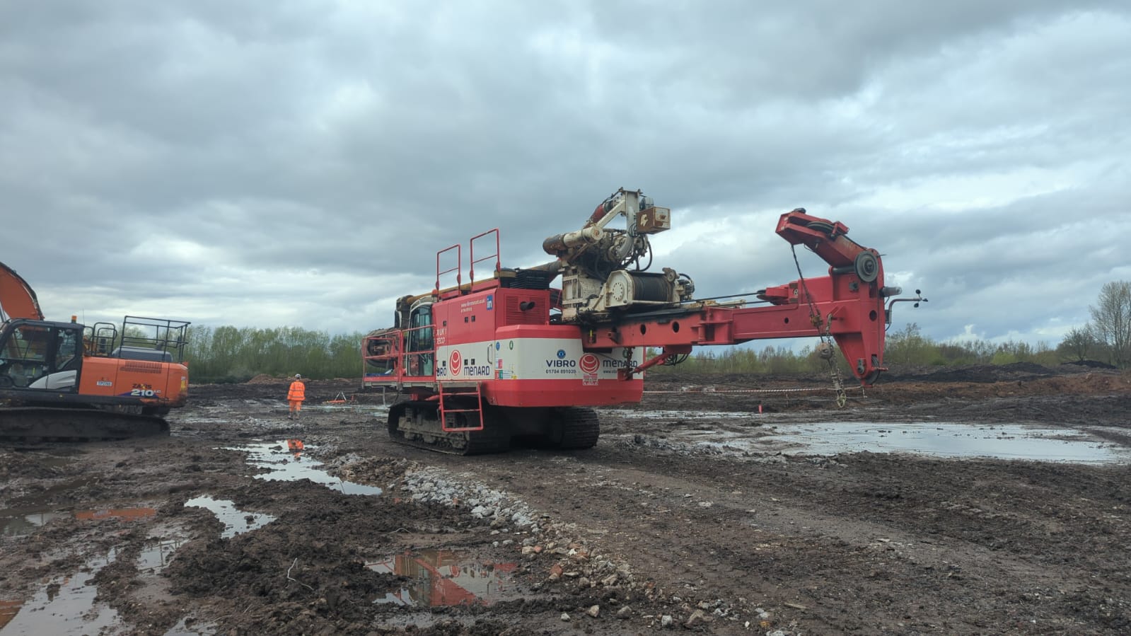 Vibro-compaction rig and excavator working on site