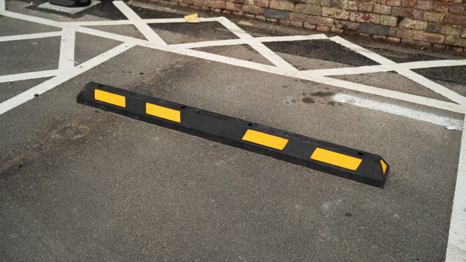 Wheel stop installed within an electric vehicle charging bay